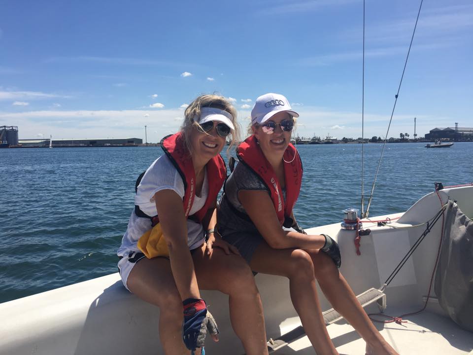 Women on a sailing boat in the sunshine learning to sail